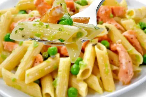 Penne z łososiem wędzonym i groszkiem na widelcu. Pyszne danie, które zachwyci każdego smakosza.