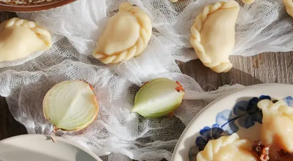 Gotowe pierogi ruskie, cebula i masło. Idealne na obiad, zgodnie z przepisem na pierogi ruskie.