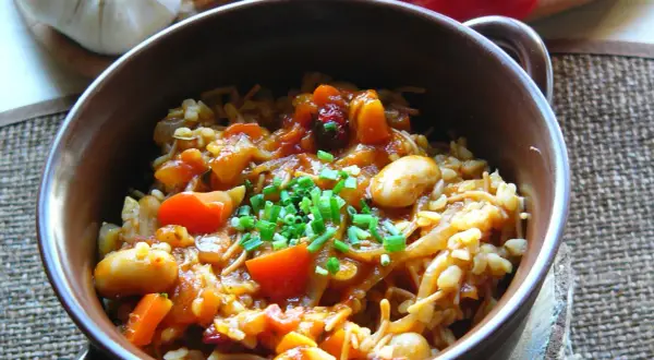 Pyszna kasza bulgur z warzywami: fasolka, pomidory, marchewka i cebulka, posypana szczypiorkiem.
