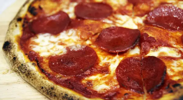 Pyszne, gorące ciasto na pizzę z serem i pikantnym pepperoni, idealne na wieczór filmowy.