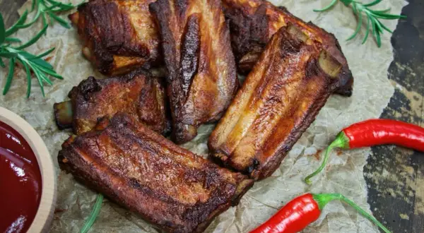 Soczyste żeberka w coli, pieczone do perfekcji, podane z sosem i papryczkami chili.