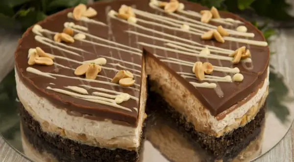Pyszne ciasto snickers bez pieczenia z czekoladą, orzeszkami i kremem. Idealne na deser.