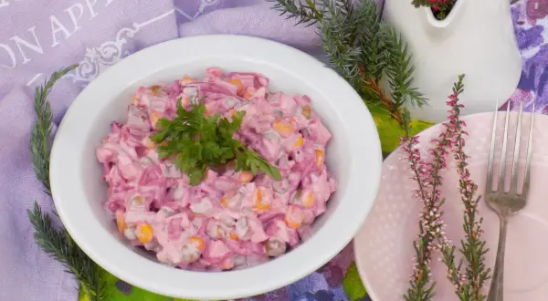 Pyszna sałatka z burakiem i jajkiem i ogórkiem kiszonym, udekorowana natką pietruszki, na stole z wrzosami.