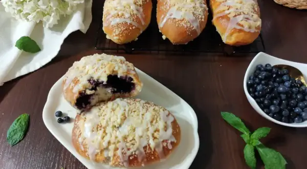 Prosty przepis na pyszne i pulchne jagodzianki z kruszonką i lukrem. Idealne na deser lub śniadanie.