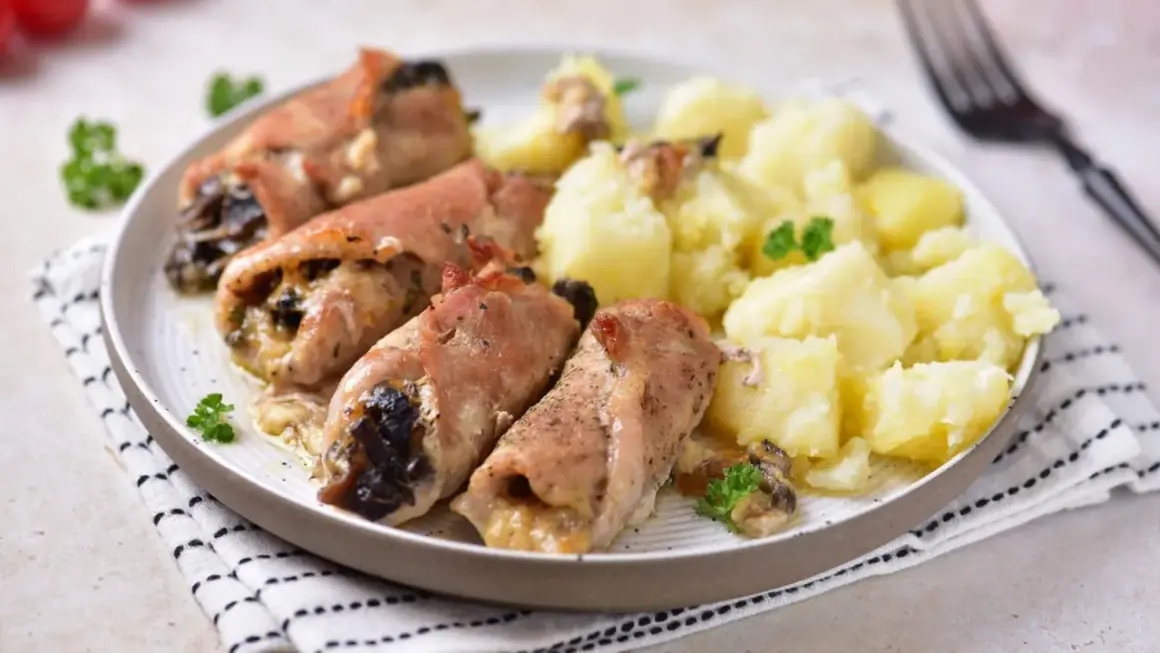 Roladki schabowe z pieczarkami, zawinięte w boczek, podane z ziemniakami i natką pietruszki. Pyszny obiad gotowy!