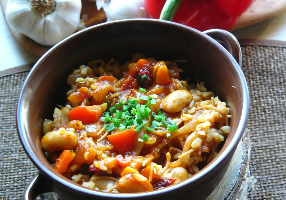 Pyszna kasza bulgur z warzywami: fasolka, pomidory, marchewka i cebulka, posypana szczypiorkiem.