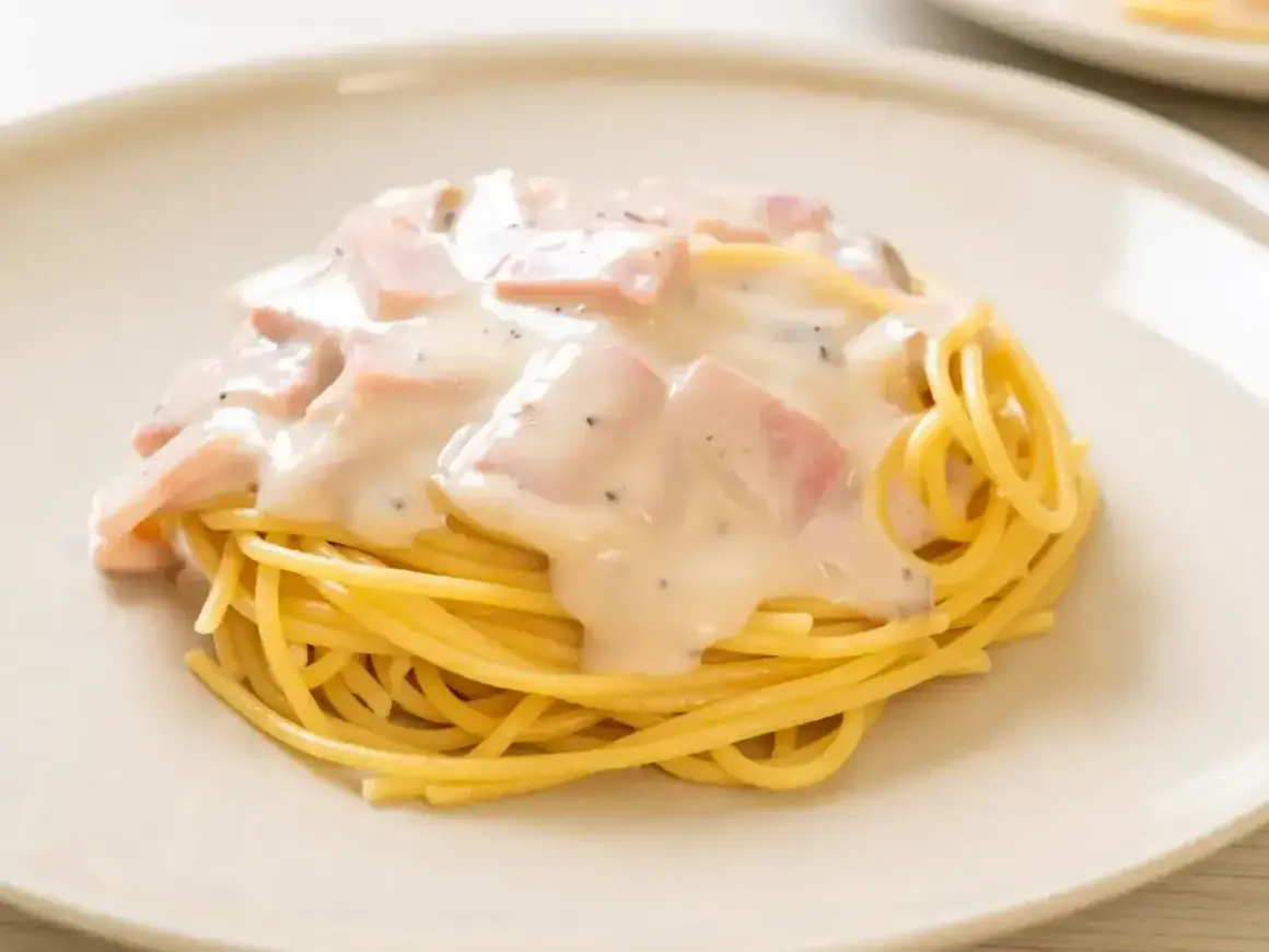 Pyszne spaghetti z kremowym sosem, kawałkami szynki i pieprzem. Prawdziwy comfort food, jak domowy mac n cheese.