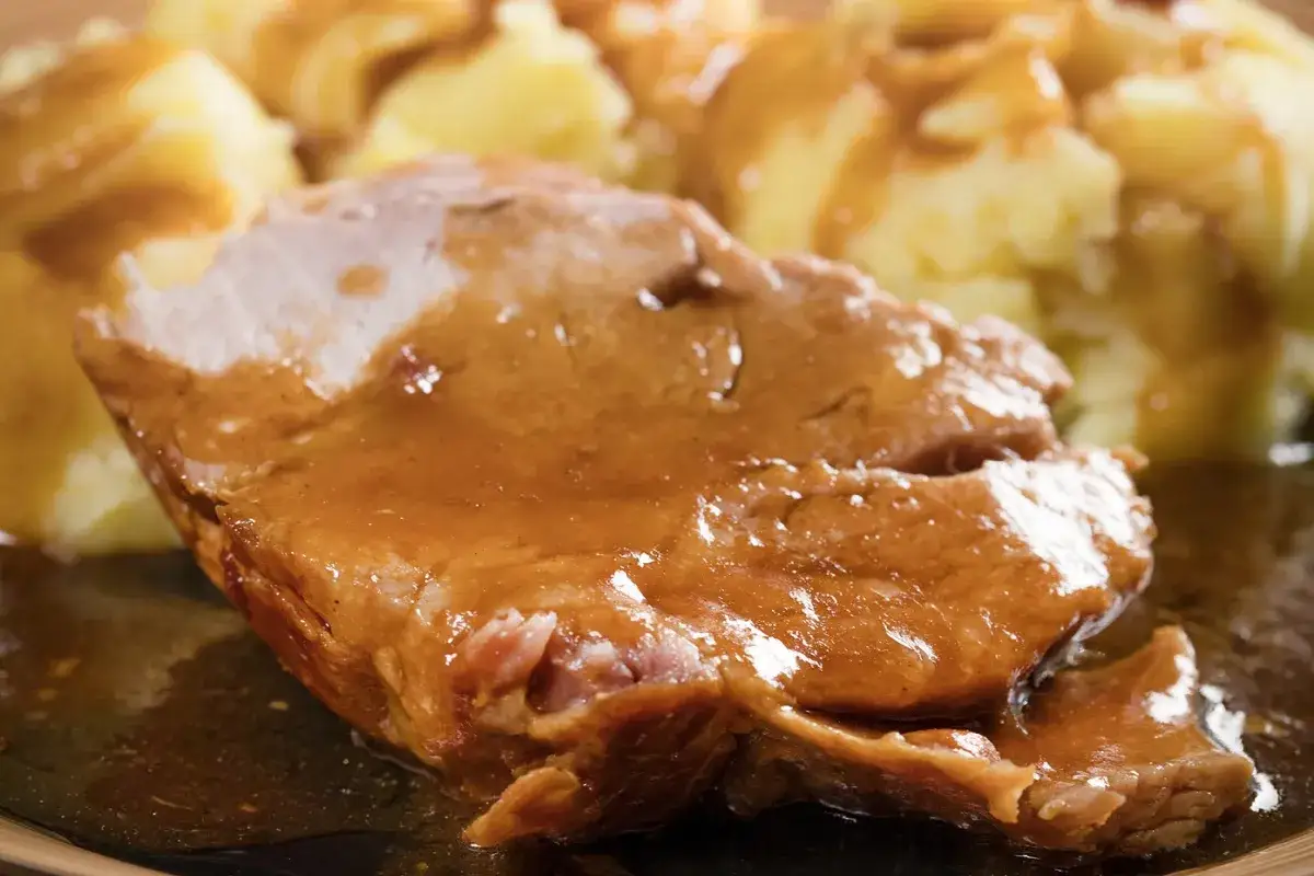 Soczysta karkówka w sosie własnym, podana z purée ziemniaczanym. Idealny obiad dla całej rodziny.