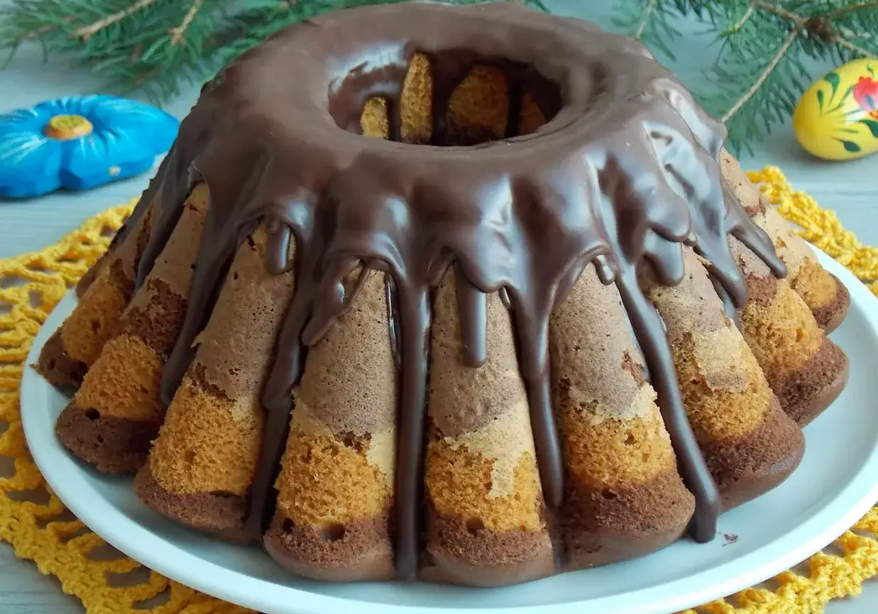 Babka Ania gotuje: marmurkowa babka z polewą czekoladową, ozdobiona pisanką i gałązką sosny.