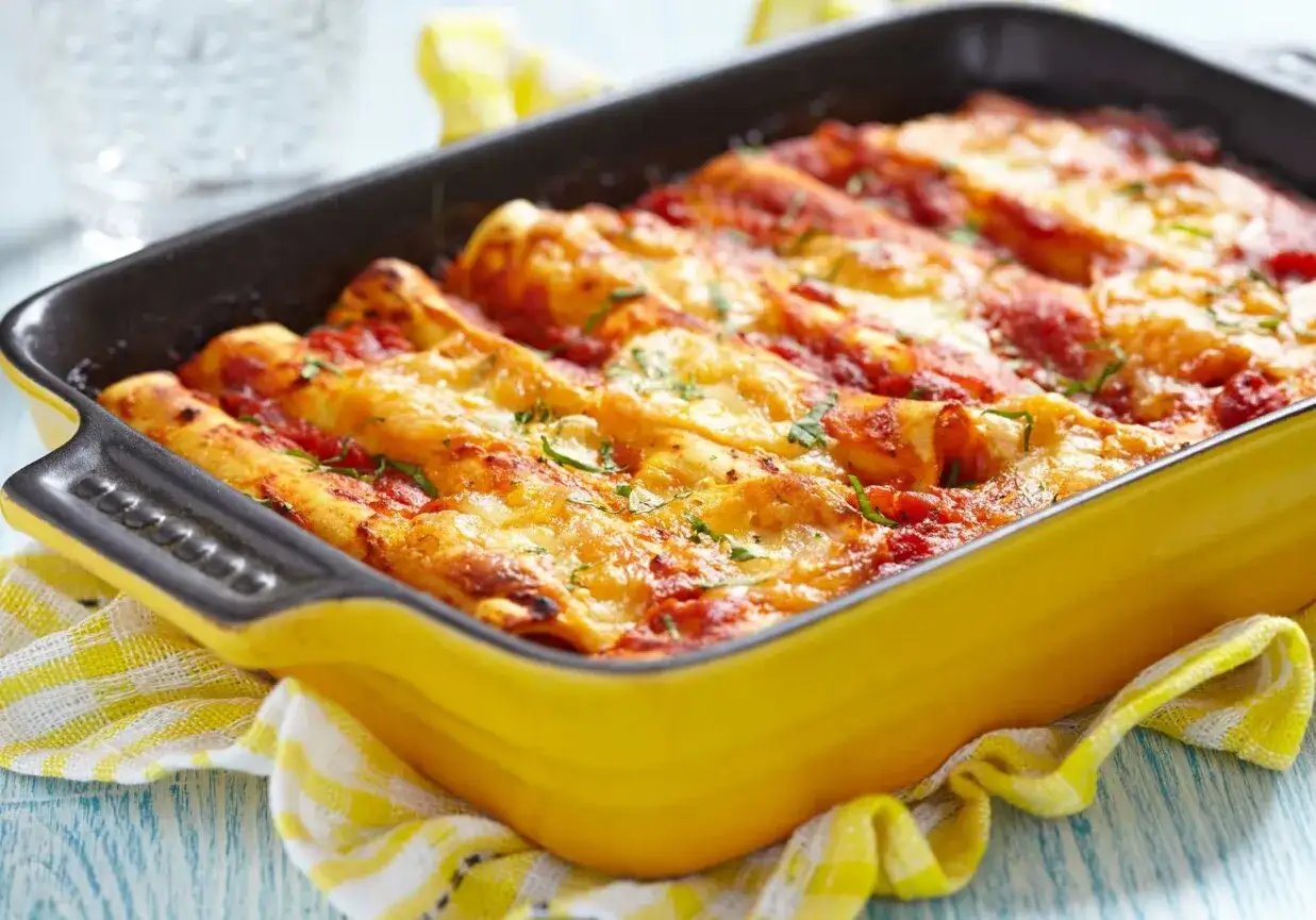 Pyszne cannelloni z mięsem mielonym, zapieczone pod sosem pomidorowym i serem, w żółtej brytfance.