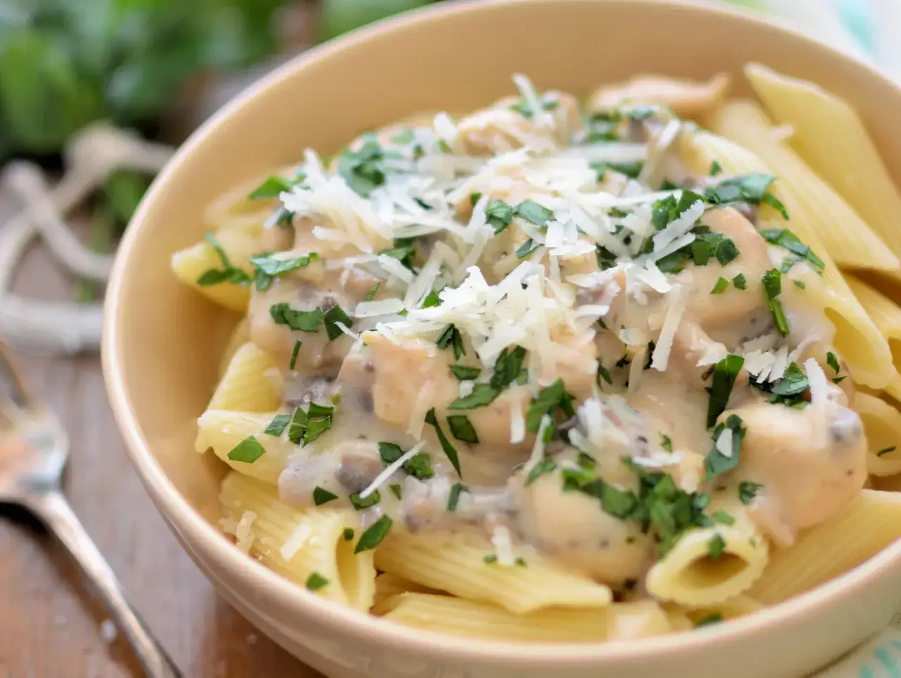 Penne z kremowym sosem pieczarkowym, posypane parmezanem i natką pietruszki. Pyszne danie, które zachwyci każdego.