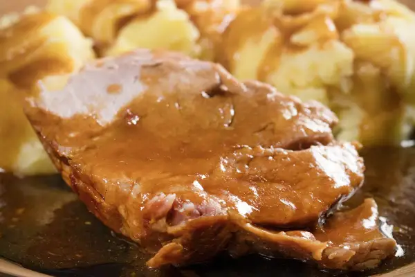 Soczysta karkówka w sosie własnym, podana z purée ziemniaczanym. Idealny obiad dla całej rodziny.