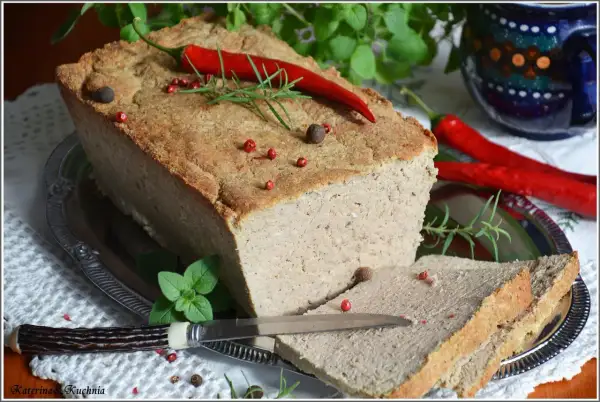 Pyszny pasztet mieszany drobiowo-wieprzowy, udekorowany papryczką chili i ziołami, gotowy do podania na kromkach chleba.