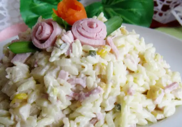 Pyszna sałatka z makaronem ryżowym, szynką i ogórkiem, udekorowana różyczkami z szynki i marchewki.