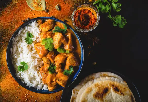 Aksamitny butter chicken przepis z ryżem i plackami naan. Aromatyczne przyprawy i świeża kolendra dopełniają danie.