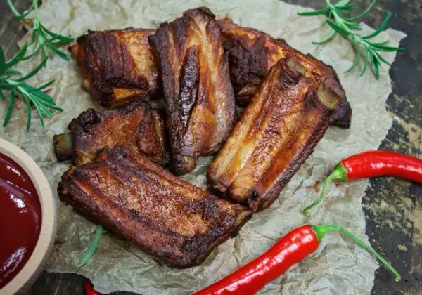 Soczyste żeberka w coli, pieczone do perfekcji, podane z sosem i papryczkami chili.