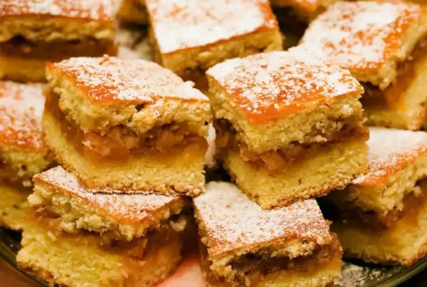 Pyszne ciasto z jabłkami, pokrojone w kostkę i posypane cukrem pudrem. Idealne na deser!