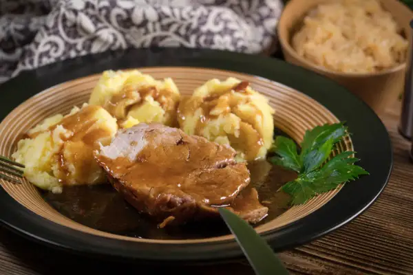 Mięciutka karkówka w sosie, podana z purée ziemniaczanym i surówką. Idealny obiad na chłodne dni.